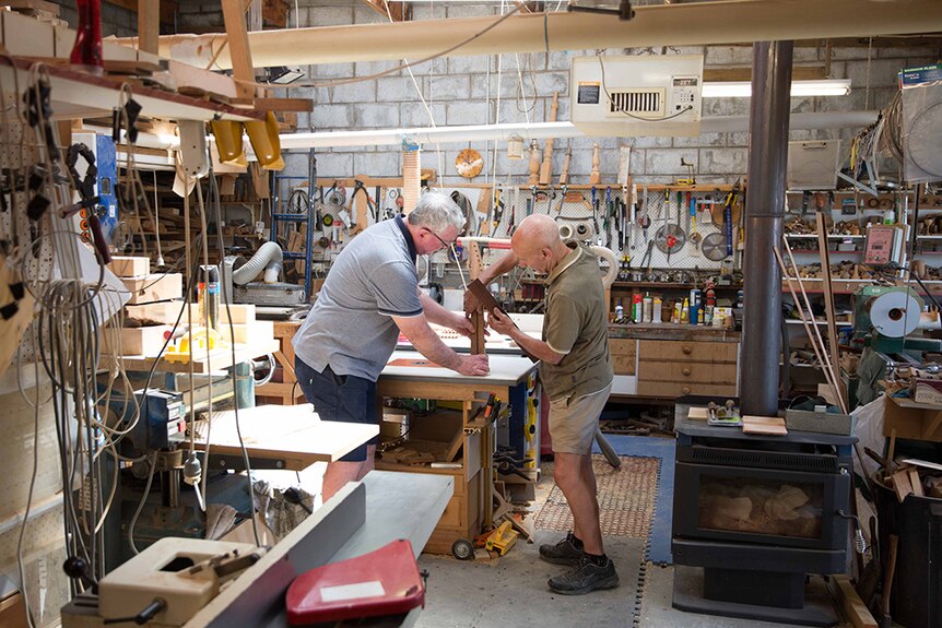 Two men working together in a wood workshop.