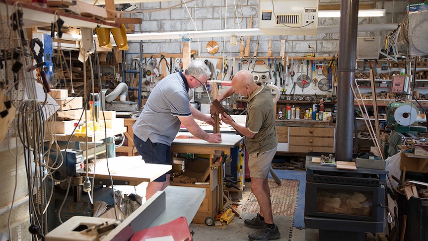 Two men working together in a wood workshop.