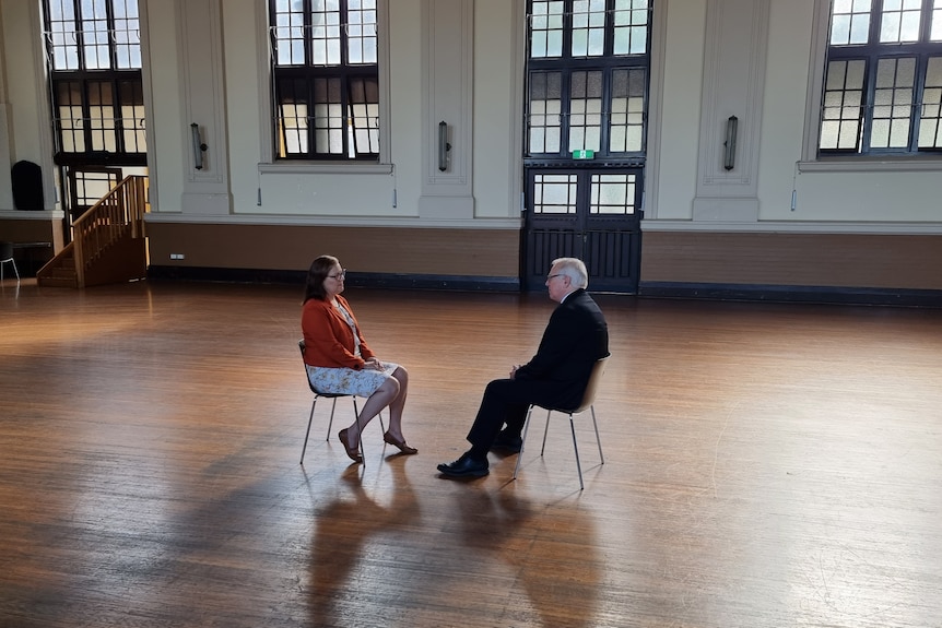 Woman and man sitting opposite each other in chairs.