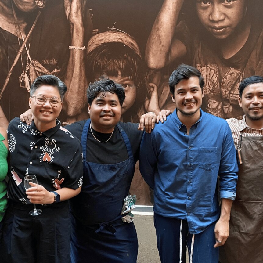 A portrait of Filipino chefs and foodies in front of a mural in a Melbourne laneway. 