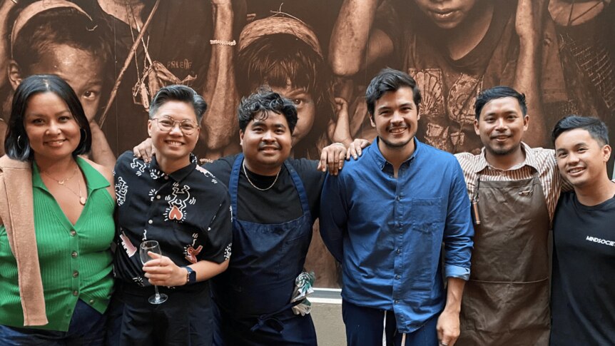 A portrait of Filipino chefs and foodies in front of a mural in a Melbourne laneway. 