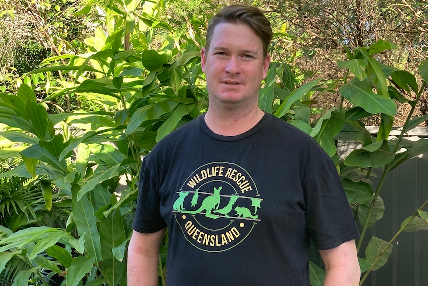 An image of Byron Cann standing in front of bushes