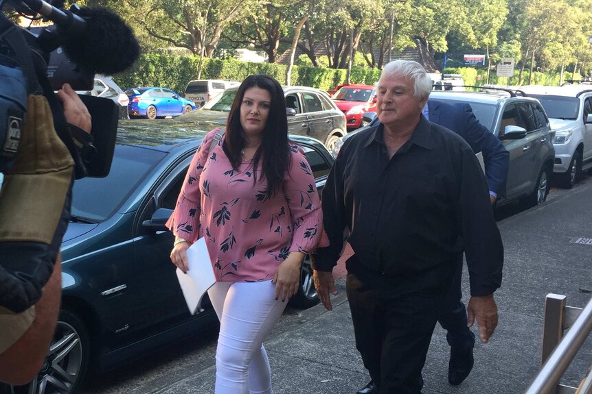 A woman and man walking on the street outside the coroner's court.