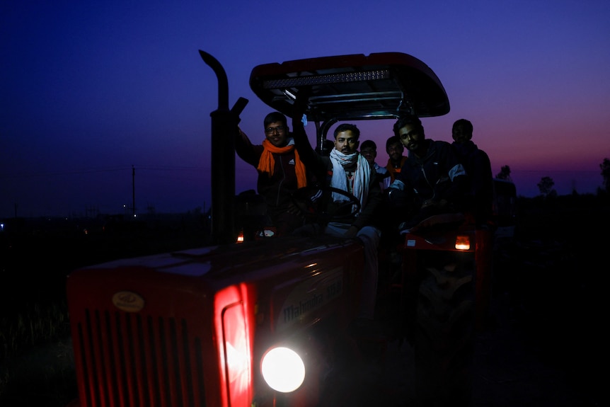 Farmers on a tractor pose for a picture, as they ride towards New Delhi to press for better crop prices.