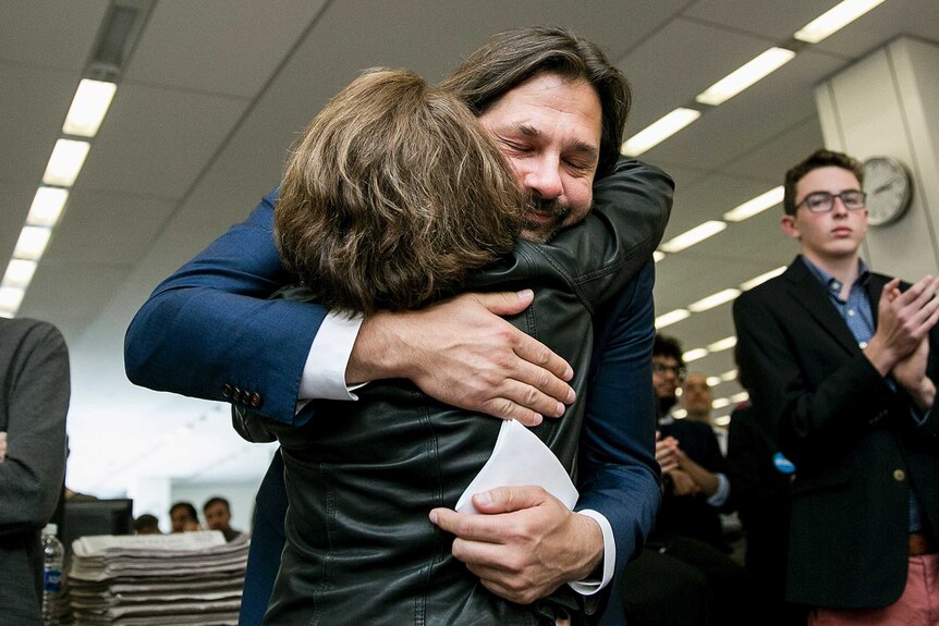 Daniel Berehulak embraces The Times' assistant editor after his win was announced.