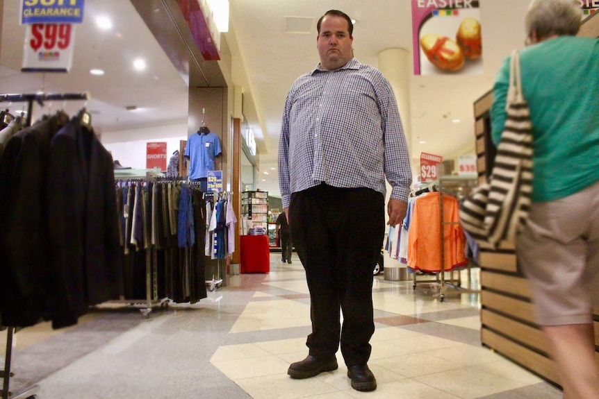 man standing in retail aisle