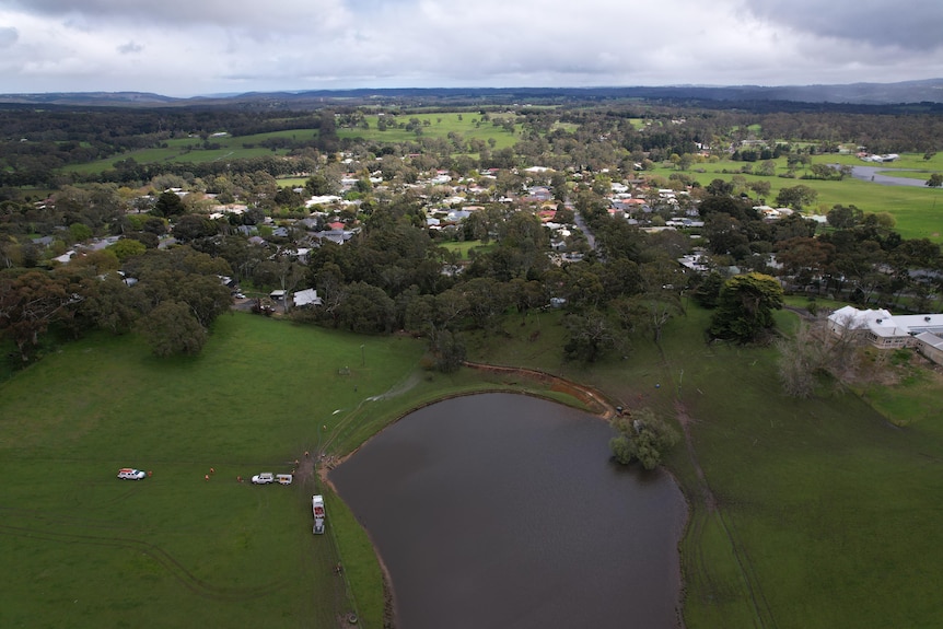 A drone photo of a dam with a town behind.