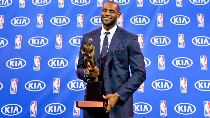 LeBron James holds with the Maurice Podoloff Trophy after being named the NBA Most Valuable Player.