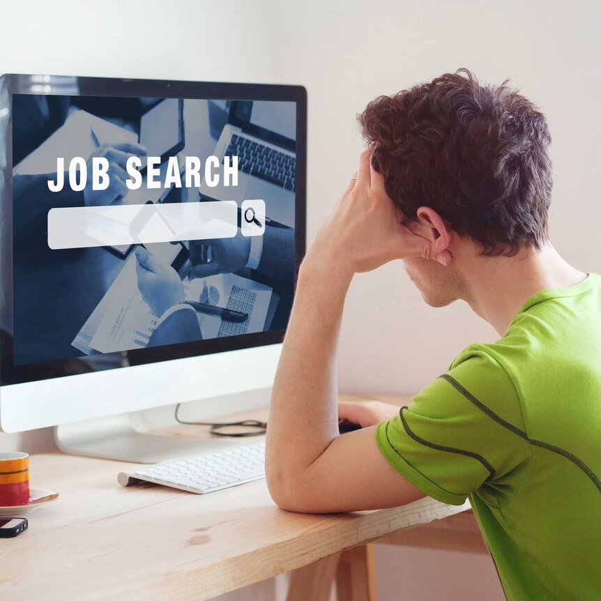 Guy sitting at a desk in front of a screen that says job search