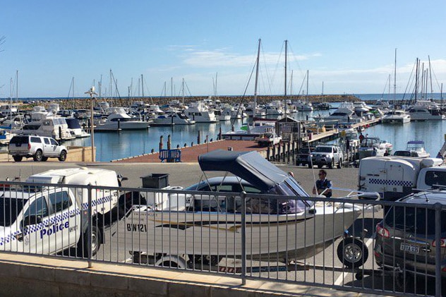 A small boat on a trailer at Mindarie Marina with police cars either side.