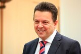 South Australian Senator Nick Xenophon smiles as he speaks to reporters in Canberra