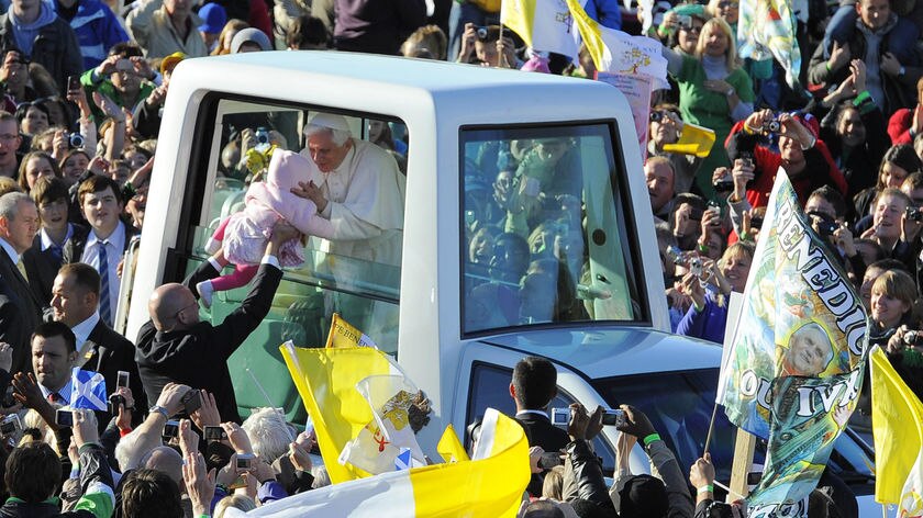 Pope Benedict XVI kissed and blessed a baby as he arrived for mass at Bellahouston Park in Glasgow.