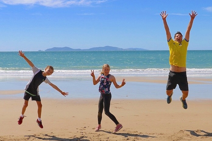 Three people on the beach jumping