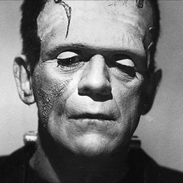 A black and white photo shows a forlorn man with theatrical makeup and skin grafts to make him look like Frankenstein.