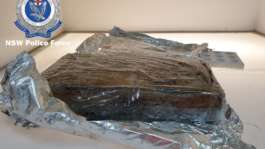 A brick of cocaine on a shelf next to aluminium foil