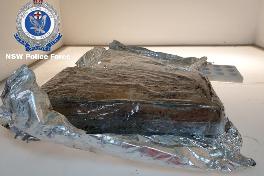 A brick of cocaine on a shelf next to aluminium foil