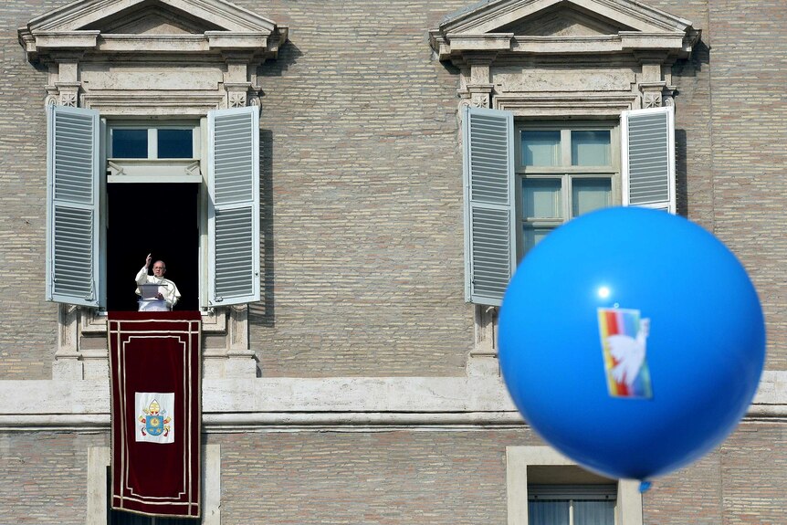 Pope Francis blesses the crowd from the window of the Apostolic Palace.