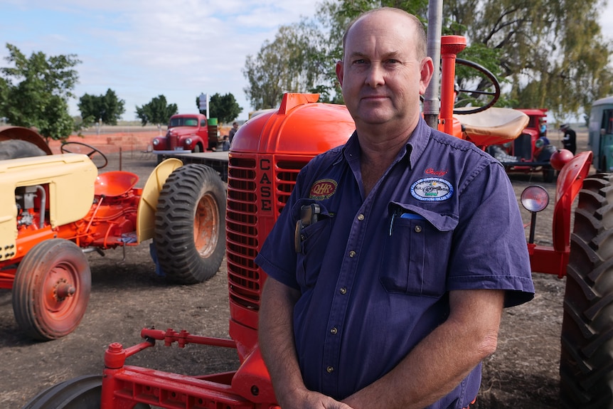 Craig Cooper stands in front of his vintage tractor