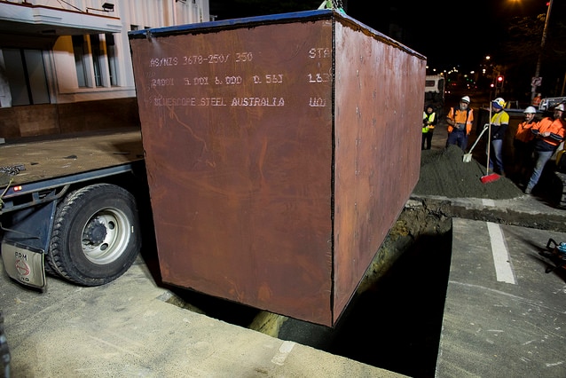 Mike Parr's enclosure is lifted into place in centre of Hobart for Dark Mofo 2018.