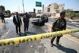 Iraqi security forces and emergency personnel gather a the site of a suicide attack.