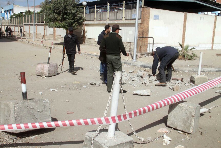 Police investigate the site of a bomb blast in front of Ain Shams police station in Cairo.