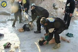 Workers hose down children in Syria