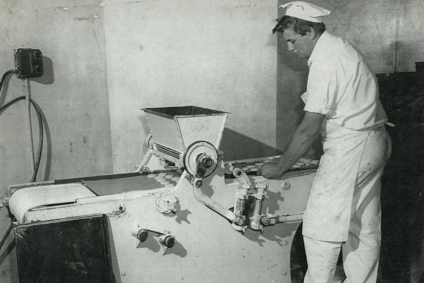 Black and white image of pastry cook at a pie machine