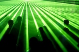 Arty shot of revellers at a rave party, with their heads poking through a green laser show