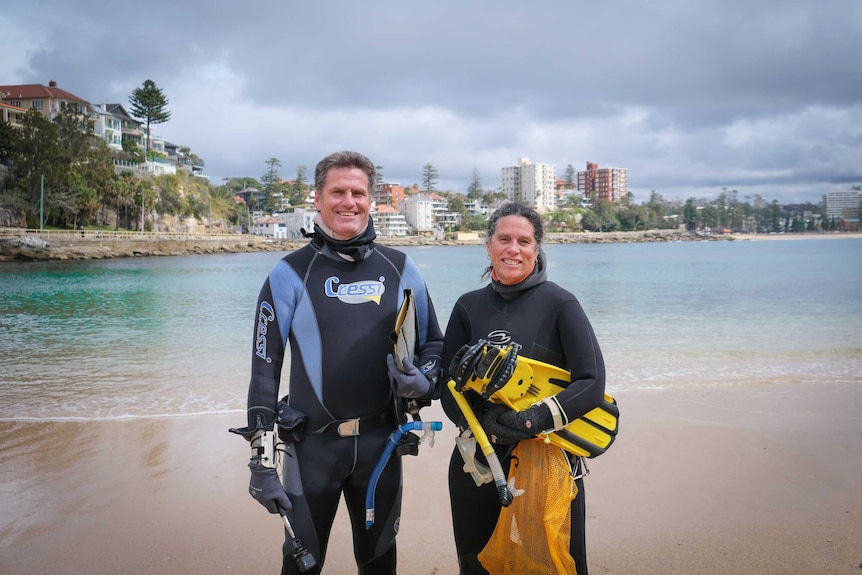 Professor David Booth and fellow UTS researcher Gigi Beretta smiling at the camera, standing in front of Shelly Beach.