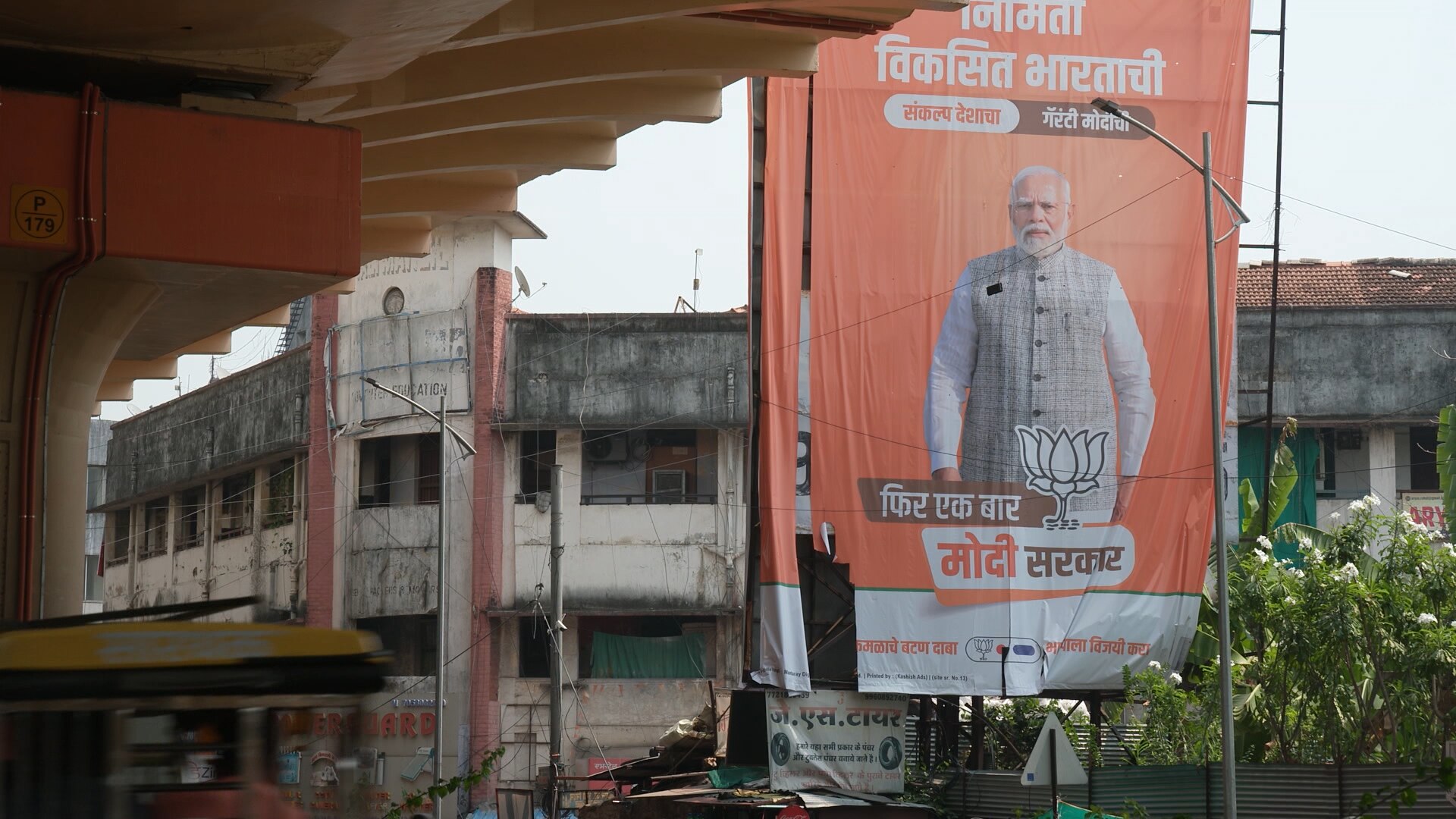 A large orange banner featuring a man in front of a run-down building.
