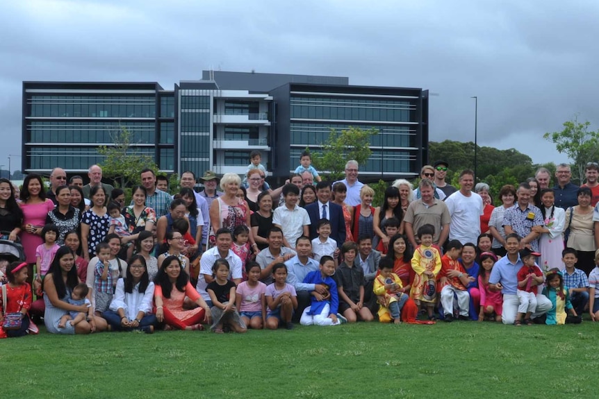 A large group of people standing on an oval for a photo