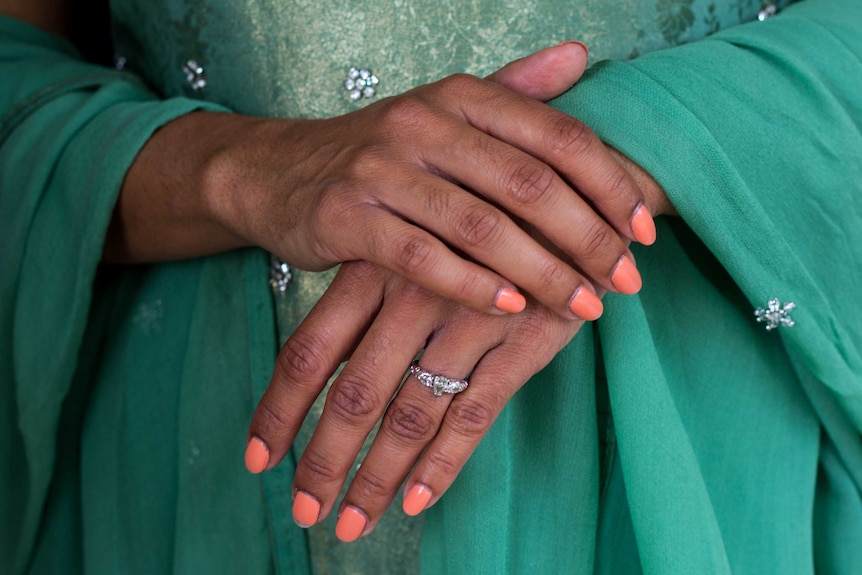 Close up of Niyati Libotte's folded hands in front of her traditional Indian dress.