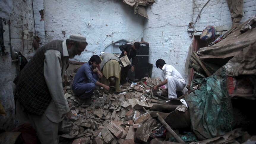 Residents search for belongings in the rubbles of a house after it was damaged by an earthquake in Peshawar, Pakistan.
