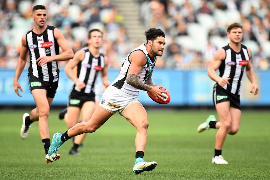 Port Adelaide's Chad Wingard (C) in action against Collingwood at the MCG on June 24, 2017.
