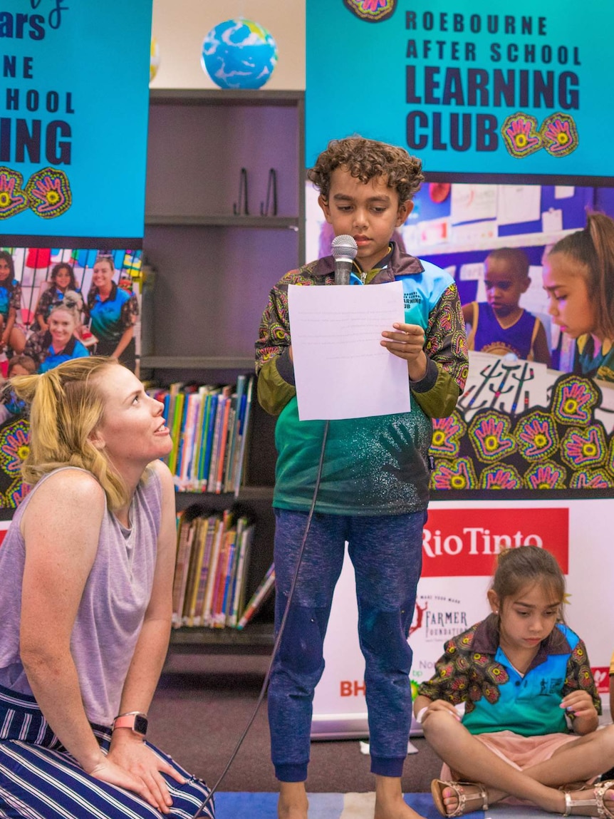 a kid with a microphone and a woman