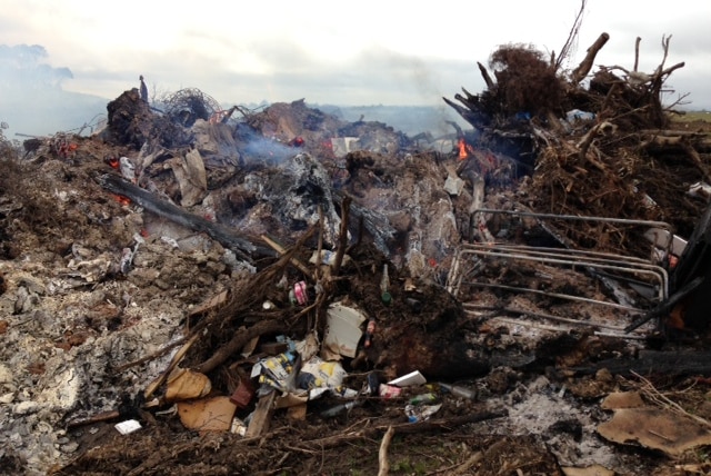 A large rubbish dump that has been torched.