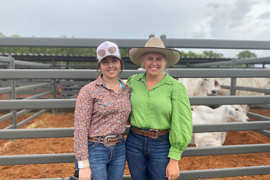 Maggie Read and Megan Kent standing in front of cattle pens at the Proserpine showgrounds.
