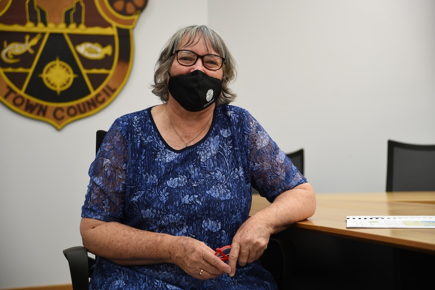 Katherine's Mayor Elisabeth Clark sits in the Civic Center wearing a mask and smiling. 