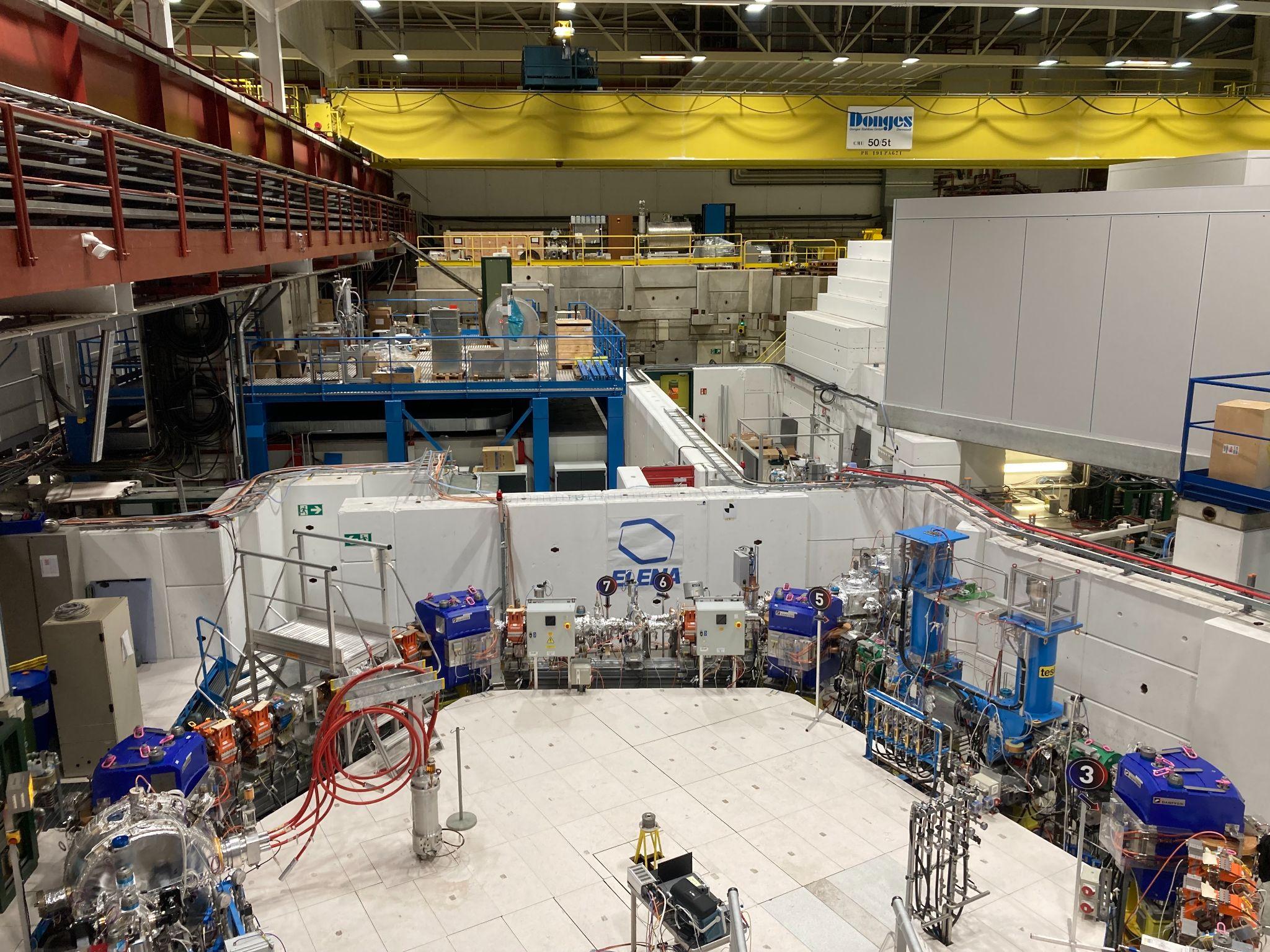 A picture from inside the Antimatter Factory showing multiple experiments and walkways in a warehouse-sized space