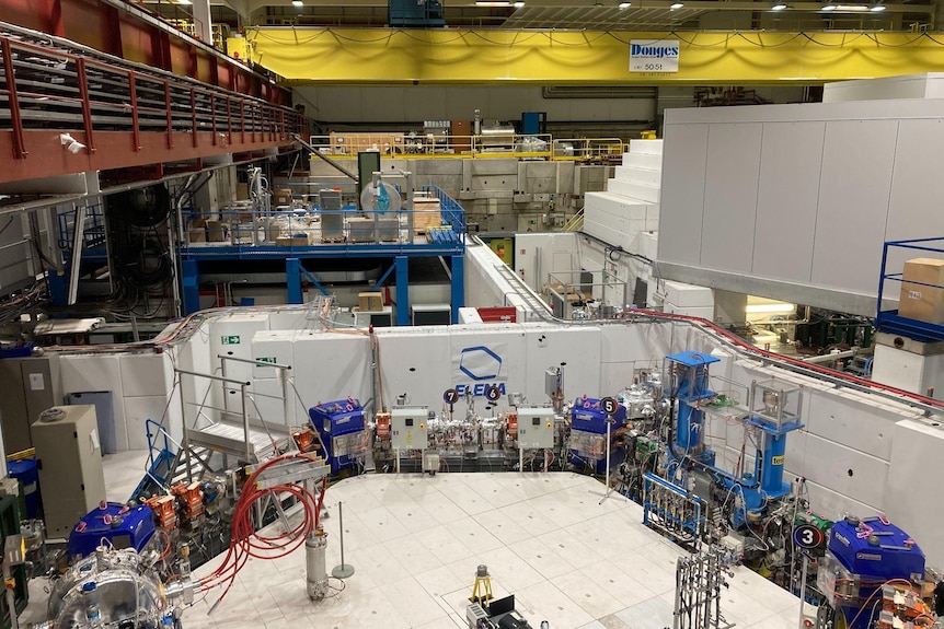 A picture from inside the Antimatter Factory showing multiple experiments and walkways in a warehouse-sized space