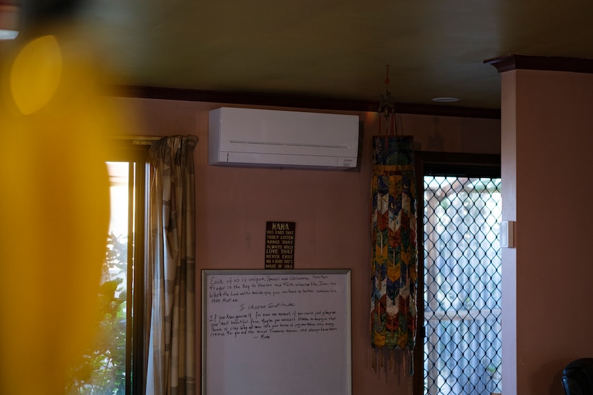 A split system unit sits high on a wall at Deb's house next to the front door.