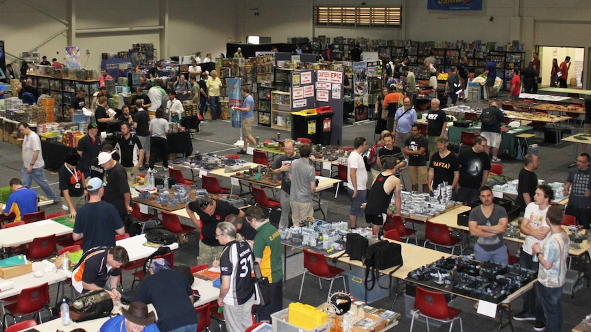 Balcony view of the convention, showing several tables set up with various games.