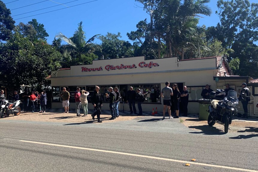Motorcyclists stand outside the Mount Glorious Cafe.