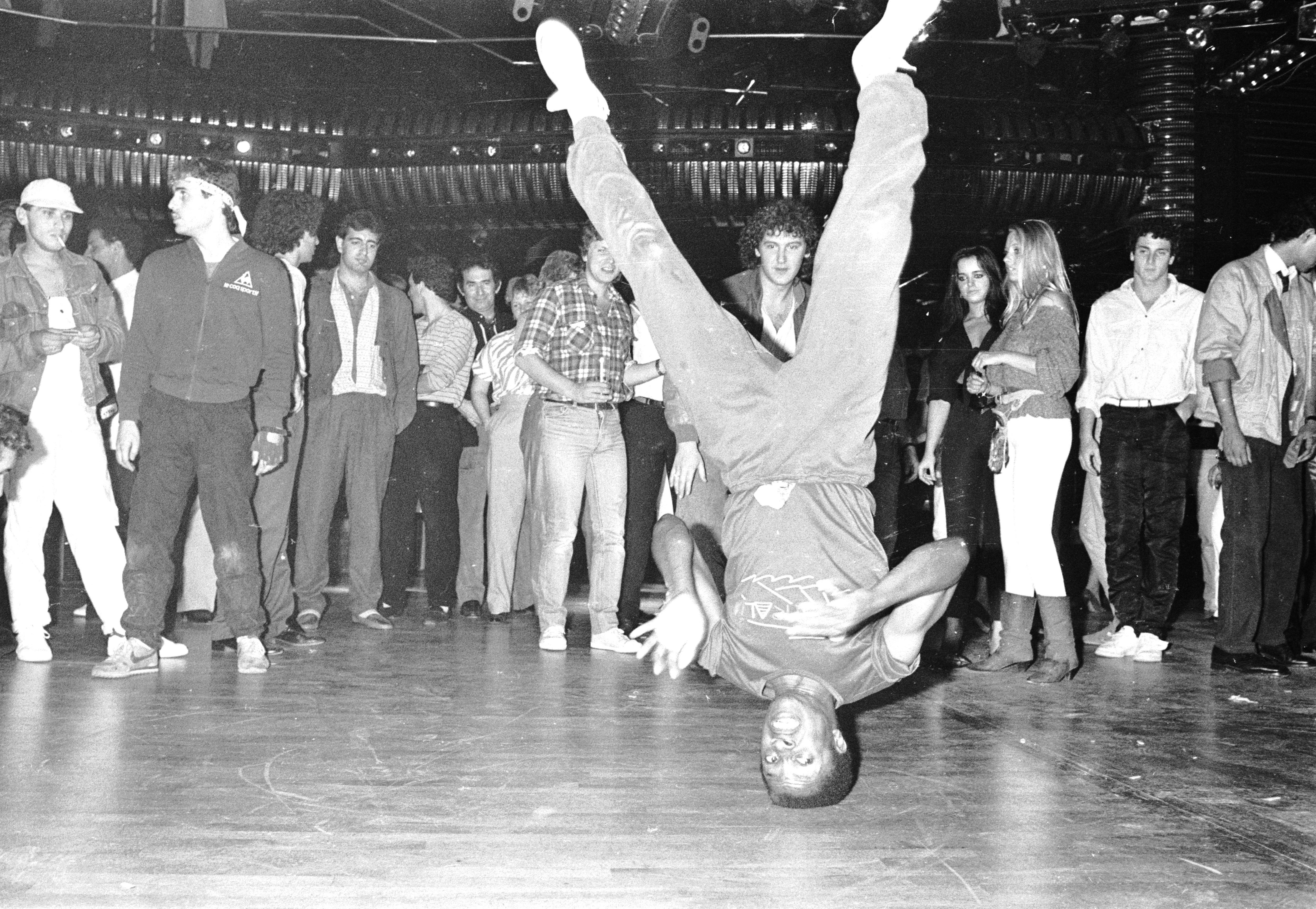 A man does a headspin in a black and white photo