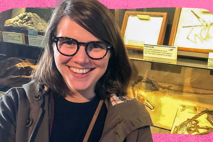 Women smiles with fossils behind her.