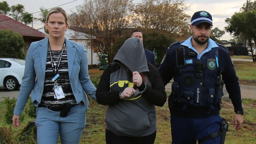A woman being escorted by police