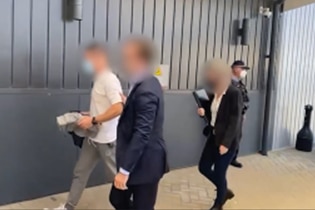 Zhenya Tsvetnenko, left, being escorted by federal officers in Perth before his extradition