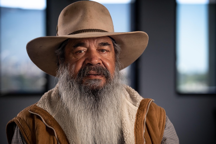 A profile shot of a man with a long beard wearing an akubra