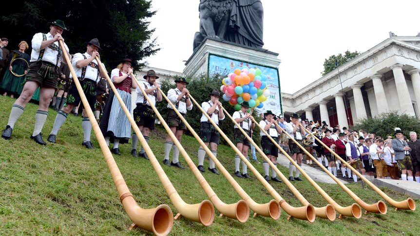 Alphorn musicians perform in front of the Bavaria monument during a concert at Oktoberfest.