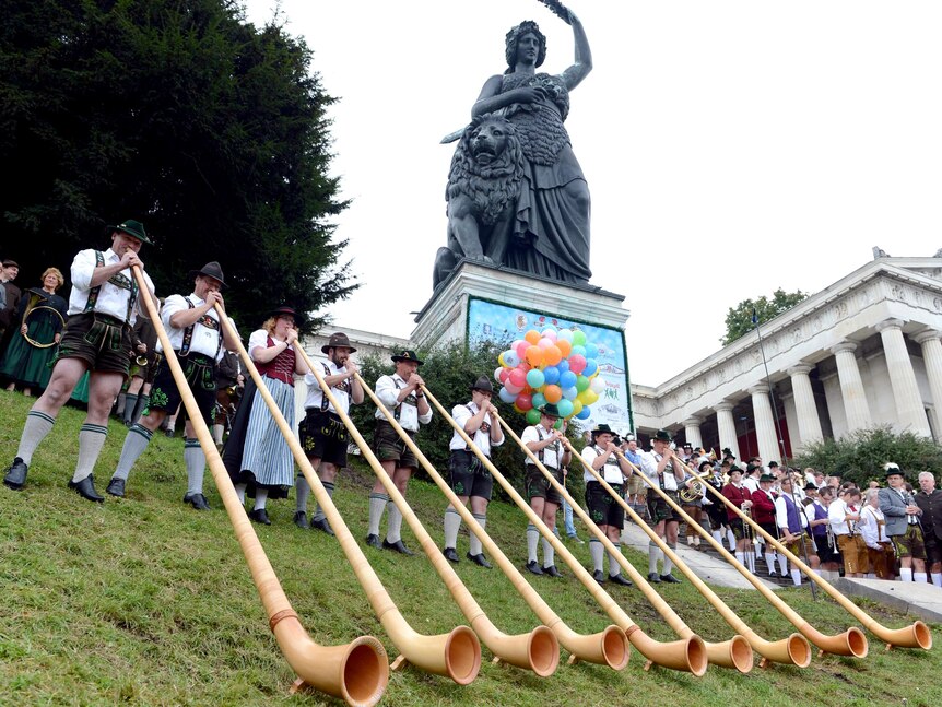 Alphorn musicians perform in front of the Bavaria monument during a concert at Oktoberfest.